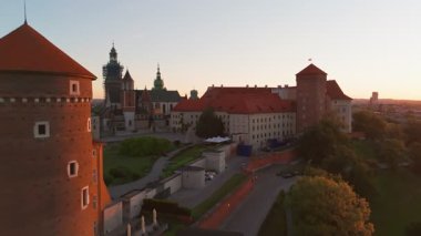 Polonya 'nın eski tarihi Krakow şehrindeki muhteşem Wawel Kalesi' nin üzerinde güzel bir gün doğumu. Wawel Hill 'deki kraliyet konutunun havadan görünüşü, sabah ışığında parlıyor.