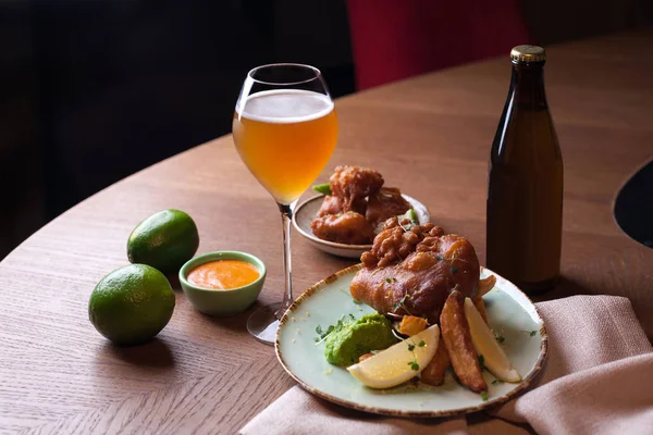 Peixe batido com batatas fritas e copo de cerveja — Fotografia de Stock