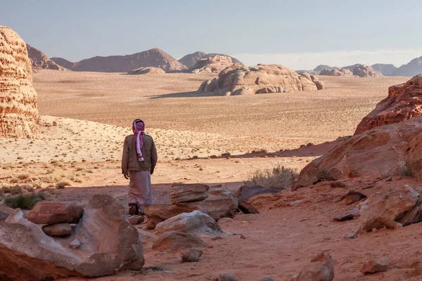贝都因人走过约旦Wadi Rum的岩石沙漠 图库照片