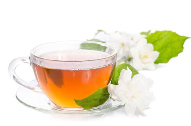 Cam bardak çay Yasemin çiçekleri ve beyaz arka plan üzerinde izole yaprakları ile