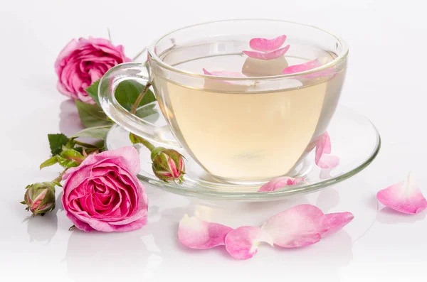 Glass cup of Tea with roses and petals