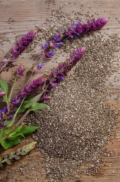 Semillas de chía con flores sobre mesa de madera —  Fotos de Stock