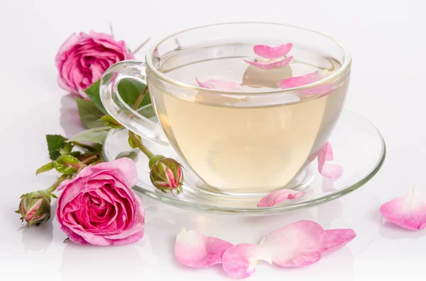 Glass cup of Tea with roses and petals