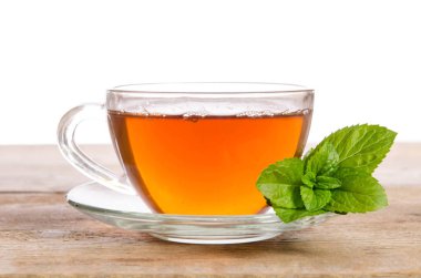 Cam bardak çay nane ile tahta masada bırakır
