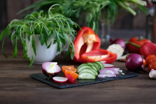 Verduras frescas rebanadas para una ensalada en una tabla de cortar —  Fotos de Stock