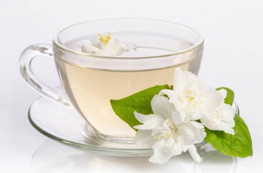 Cam bardak çay Yasemin çiçekleri ve yaprakları ile
