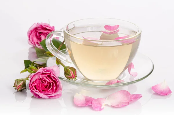 Glass cup of Tea with roses and petals