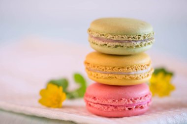 güzel sarı çiçekli havlu üzerinde renkli macarons gelen kule