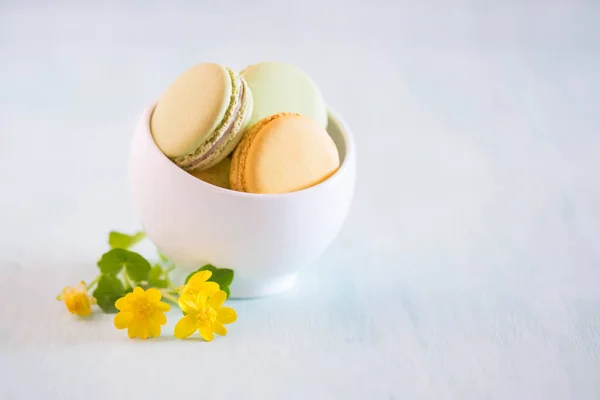 Macarons Biały Drewniany Stół Piękno Żółte Kwiaty — Zdjęcie stockowe