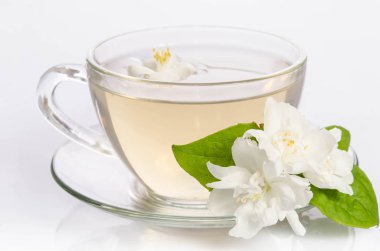Cam bardak çay Yasemin çiçekleri ve yaprakları ile
