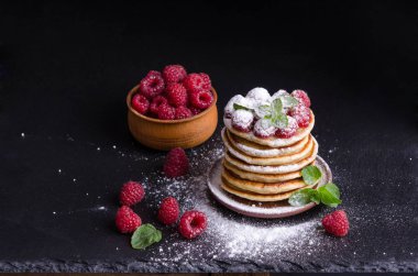 Ahududu ile krep ve çevresinde siyah artalan üzerinde çilek