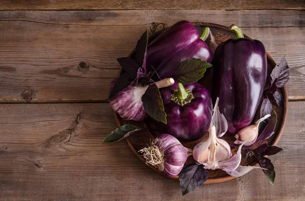 Paprika ungu gelap dengan daun kemangi dan bawang putih pada karat tua — Stok Foto