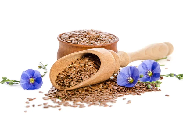Semillas de lino en la cuchara y tazón de madera, flores de belleza aisladas — Foto de Stock