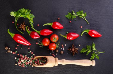 Domates ve biber siyah bir arka plan ile farklı baharatlar