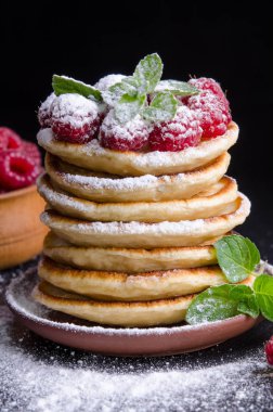 Ahududu ile krep ve çevresinde siyah artalan üzerinde çilek