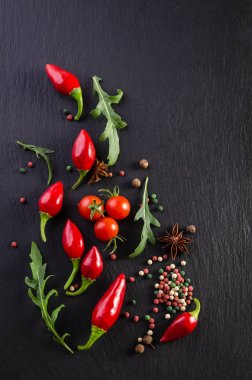 Domates ve biber siyah bir arka plan ile farklı baharatlar