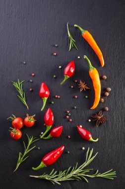 Domates ve biber siyah bir arka plan ile farklı baharatlar