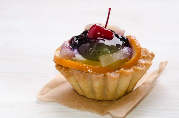 Torta cestino decorato con frutta diversa su tavolo bianco — Foto Stock