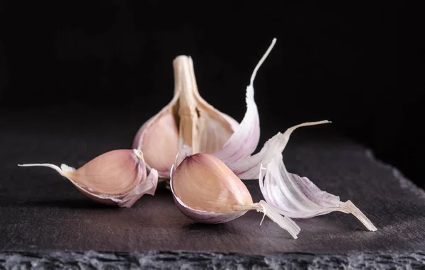 Garlic on black stone table on black background — Stock Photo, Image