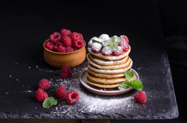 Ahududu ile krep ve çevresinde siyah artalan üzerinde çilek