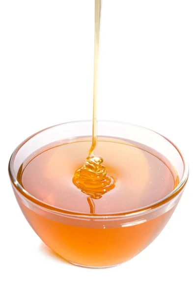 흰색 바탕에 유리 그릇에 꿀을 붓는 — 스톡 사진