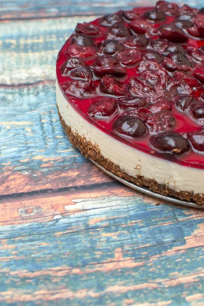 Cold cheesecake with cherry jelly on table