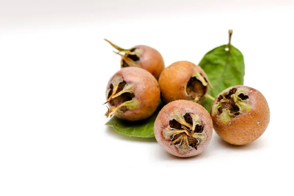 Ceviz ve medlars beyaz bir arka plan üzerinde yığını