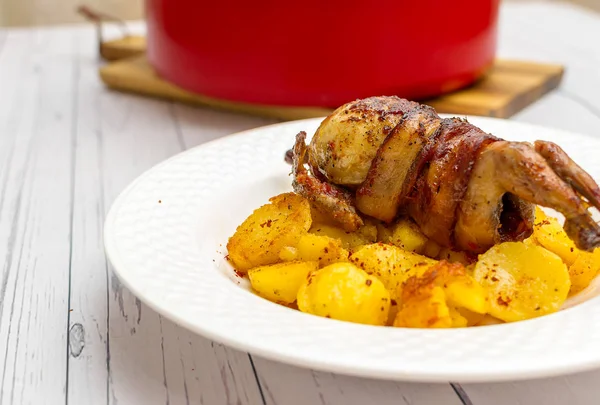 Roasted quail wrapped in bacon and sauteed potatoes — Stock Photo, Image