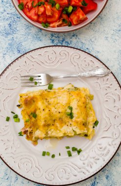 Bir parça taze pişmiş lazanya ve tabakta kızarmış ekmek.