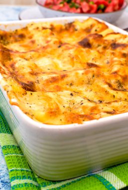 Taze pişmiş lazanya ve kızarmış kabuklu seramik tepsi.