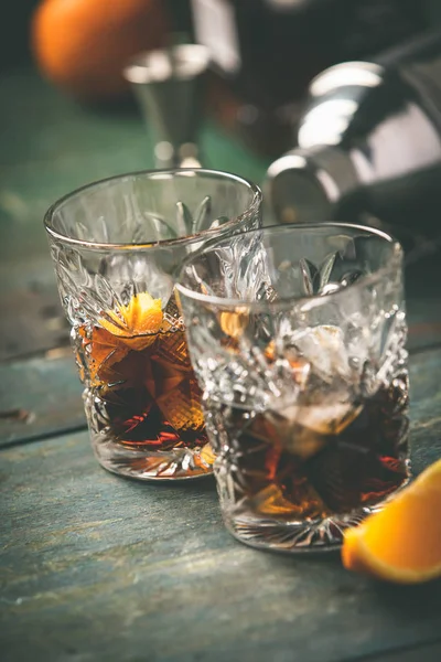 Alcoholische cocktail met sinaasappelschil en ijs — Stockfoto