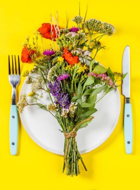 Beyaz tabakta düz bir çiçek buketi. Temiz yemek, paleo, biyohack, bitkisel tıp konsepti