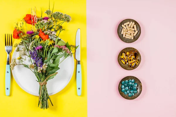白プレート ハーブ カプセル野生花の花束のフラットが横たわっていた きれいに食べる Biohacking 漢方医学の概念 — ストック写真
