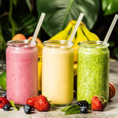 Tropikal arka plan üzerinde taze smoothies
