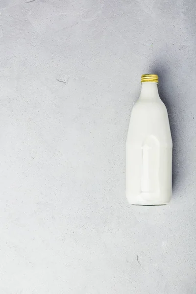 Flasche Milch auf grauem Betonhintergrund — Stockfoto