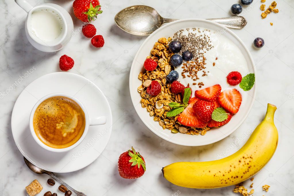 Healthy breakfast with coffee, yogurt, granola and berries