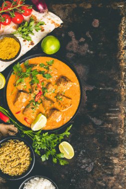 Geleneksel köri ve malzemelerin koyu arka plan üzerine. Köri, limon, zencefil, biber, naan ekmek, pirinç, kuskus, otlar ve baharatlar yat