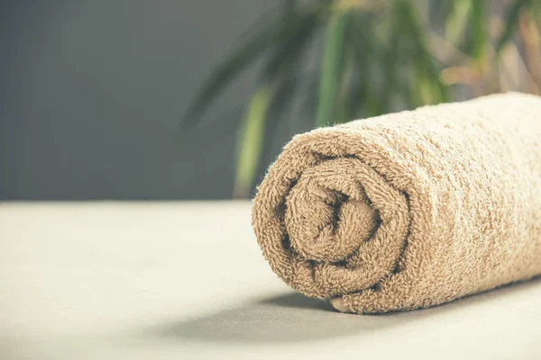 Braunes Handtuch auf Betongrund - Wellness- und Entspannungskonzept — Stockfoto