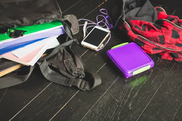 Opened schoolbag on the black wooden floor — Stock Photo, Image