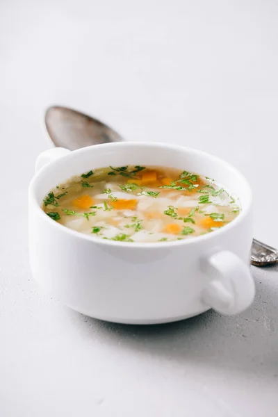Bílá miska domácí zeleninové polévky na konkrétní pozadí — Stock fotografie