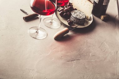 Beton zeminde kırmızı şarap ve peynir