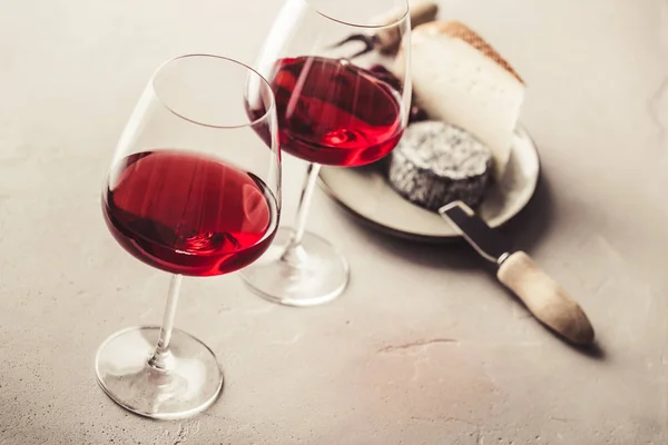 Vin rouge et fromage sur fond de béton — Photo