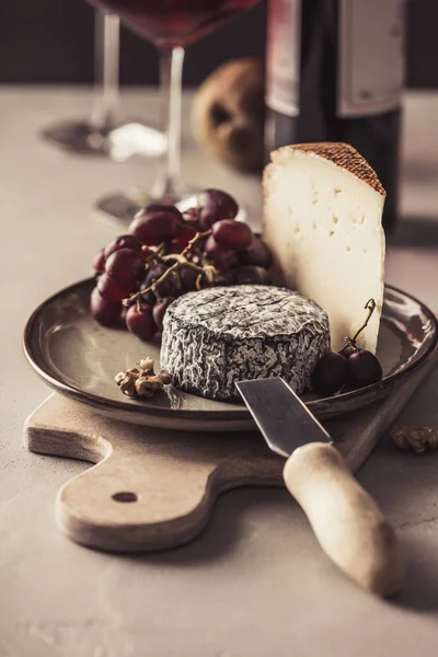 Meyve ve fındık ile kırmızı şarap ve peynir tabağı — Stok fotoğraf