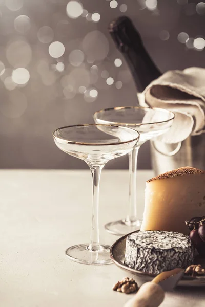 Šampaňské a tác se sýrem na konkrétní pozadí — Stock fotografie