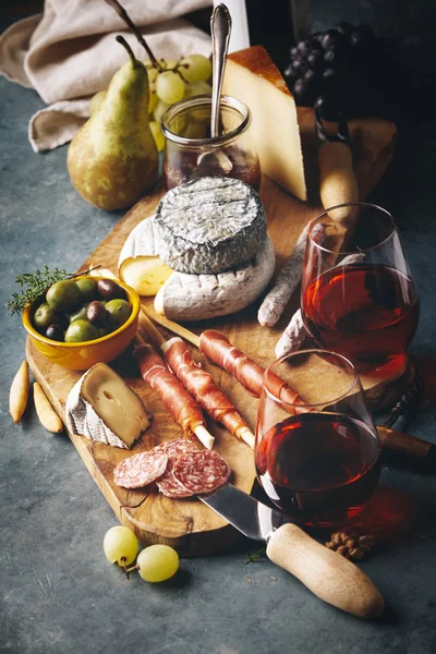 Vino rosso con assortimento di salumi sullo sfondo in pietra — Foto Stock
