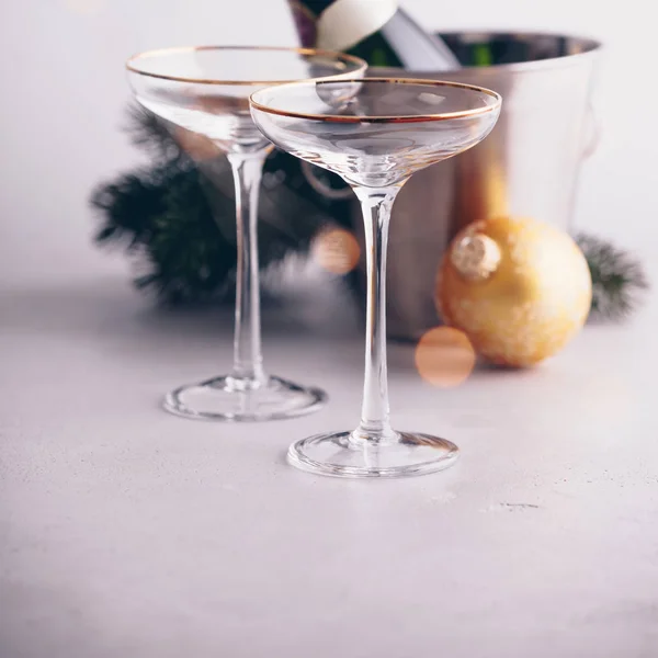 Láhev šampaňského v kbelíku s ledem, brýle a vánoční výzdoba — Stock fotografie