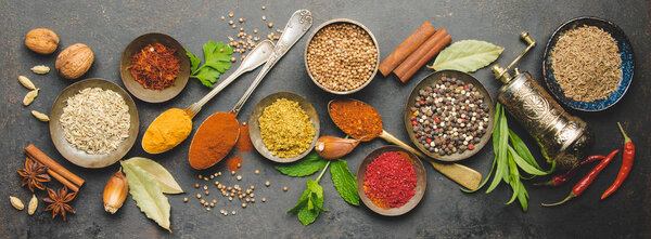 Herbs and spices on dark background, flat lay