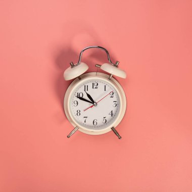 Pembe arka planda beyaz alarm saati 