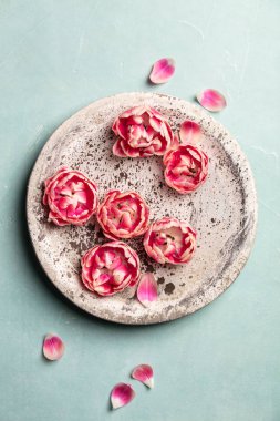 Mavi arka planda suda yüzen pembe çiçekler, SPA ve rahatlama konsepti