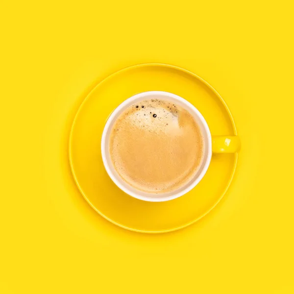 Yellow coffee cup on yellow background, flat lay — Stock Photo, Image